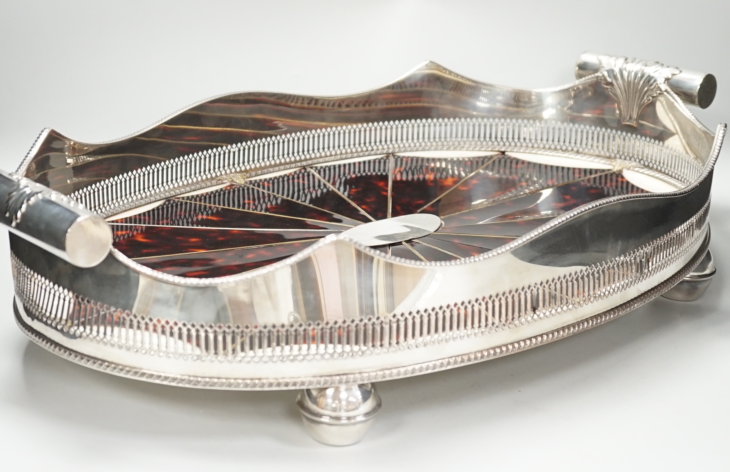 An unusual Adam style tortoiseshell and mother-of-pearl inlaid plated oval with ‘paterae’ decoration, 65cm wide